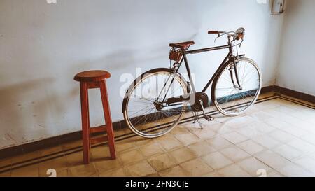 Der Mann geht zu einem Vintage-Friseurladen, um sich die Haare zu schneiden, das Fahrrad ist eine Zierde oder das Transportmittel des Besitzers Stockfoto