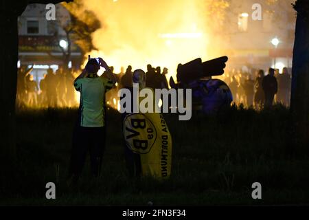 Dortmund, Deutschland. Mai 2021. Fußball: DFB-Cup, RB Leipzig - Borussia Dortmund, Finale: Zwei BVB-Fans folgen ihm die Dortmunder Ultra-Fans feiern mit Bengalos am Borsigplatz. Quelle: Bernd Thissen/dpa/Alamy Live News Stockfoto