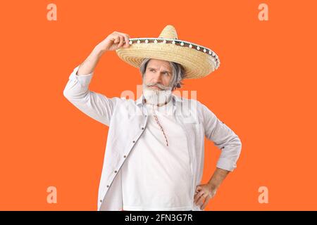 Älterer Mann in Sombrero-Hut auf farbigem Hintergrund Stockfoto