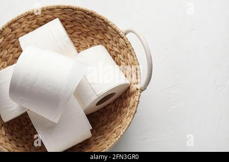 Korbkorb mit Rollen Toilettenpapier auf weißem Hintergrund Stockfoto