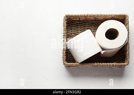 Korbkorb mit Rollen Toilettenpapier auf weißem Hintergrund Stockfoto