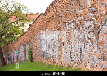 Ziegelwand mit Graffiti. Alte Verteidigungsmauer in der Stadt Brünn. Frühling in der Tschechischen Republik. Stockfoto