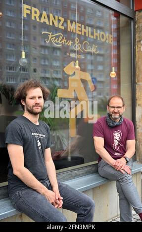 Erfurt, Deutschland. Mai 2021. Philip (r) und Ralf (l) Neues, die gemeinsam das 'Franz Mehlhose Kultur und Cafe' führen, sitzen vor ihrem Club. Statt Live-Musik für das Publikum gibt es derzeit nur Burger, die man aus der Küche mitnehmen kann. Viele Vertreter der thüringischen Clubkultur hoffen, ihrem Publikum, zumindest im Außenbereich, ab dem Sommer nach der langen Corona-Schließung wieder etwas bieten zu können. Quelle: Martin Schutt/dpa-Zentralbild/dpa/Alamy Live News Stockfoto