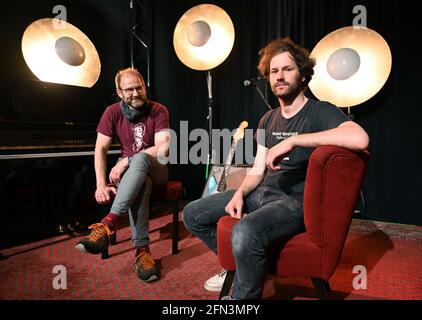 Erfurt, Deutschland. Mai 2021. Philip (r) und Ralf (l) Neues, die gemeinsam das 'Franz Mehlhose Kultur und Cafe' führen, sitzen in ihrem Club auf der Bühne. Statt Live-Musik für das Publikum gibt es derzeit nur Burger, die man aus der Küche mitnehmen kann. Viele Vertreter der thüringischen Clubkultur hoffen, ihrem Publikum, zumindest im Außenbereich, ab dem Sommer nach der langen Corona-Schließung wieder etwas bieten zu können. Quelle: Martin Schutt/dpa-Zentralbild/dpa/Alamy Live News Stockfoto