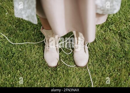 Ungebundene Schnürsenkel Damenschuhe weiß auf Gras Stockfoto