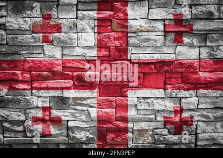 Nationalflagge von Georgien auf Steinmauer Hintergrund.das Konzept der nationalen Stolz und Symbol des Landes. Flag Banner auf Stein Textur Hintergrund. Stockfoto
