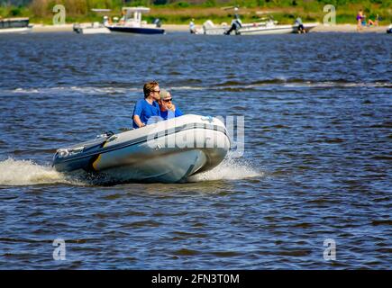 Ein Vater und ein Sohn fahren ihr Schlauchboot am 8. Mai 2021 in Biloxi, Mississippi, vorbei an Deer Island im Biloxi Small Craft Harbour. Stockfoto