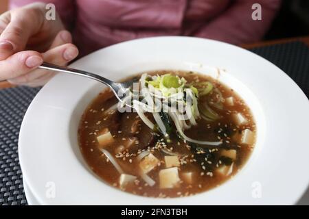Person, die Miso-Suppe in einem Restaurant isst Stockfoto