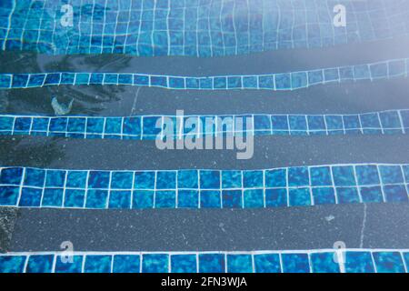 Wellige blaue Fliesen in einem Schwimmbad schaffen eine abstrakte Form Muster Stockfoto