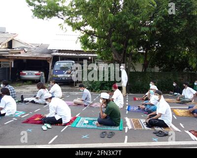 Editorial Photo, 13. Mai 2021, Indonesien, Ost-Jakarta, an der Straße vor der Mesjid- oder Fahahilah-Moschee sitzender Islammann mit der Medina-Maske, Listeni Stockfoto