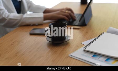 Kurze Aufnahme einer Geschäftsfrau, die während der Arbeit auf der Tablet-Tastatur tippt Im Büroraum Stockfoto