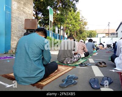 Editorial Photo, 13. Mai 2021, Indonesien, Ost-Jakarta, an der Straße vor der Mesjid- oder Fahahilah-Moschee sitzender Islammann mit der Medina-Maske, Listeni Stockfoto