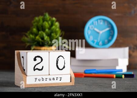 Februar. Februar 20 Holzwürfelkalender mit unscharfen Objekten auf dem Hintergrund. Stockfoto