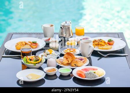 Amerikanisches Frühstück auf dem Tisch neben dem Pool im Resort Stockfoto