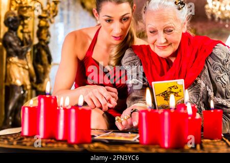 Wahrsager Festlegung Tarot Karten mit Client auf pentagramm, Kerzen brennen Stockfoto