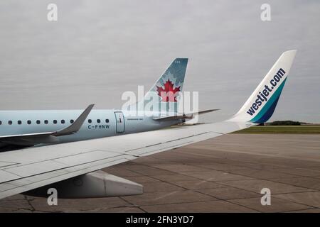 WestJet- und Air Canada-Flugzeuge parkten auf Asphalt bei John G Diefenbaker Flughafen in Saskatoon Stockfoto