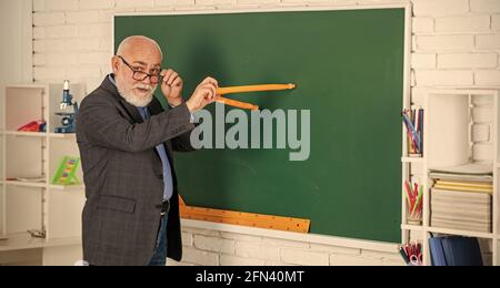 Mach wie ich. Studiere Mathematik, um gute Ergebnisse zu erzielen. Senior man Lehrer verwenden Kompass-Werkzeug. Bärtiger Tutor Mann zeichnen mit Kompass auf Tafel. Zurück zur Schule Stockfoto