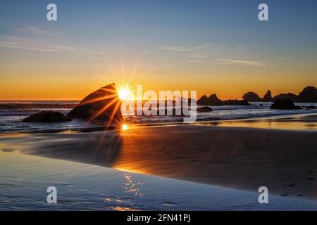 Lone Ranch Beach bei Sonnenuntergang mit doppeltem Sonnenstern, Samuel H. Boardman State Scenic Corridor, Oregon Stockfoto