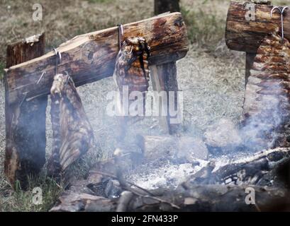 Geräucherte Schweineribs am Lagerfeuer. Fleisch ist Kochen in der alten mittelalterlichen Weise. Stockfoto