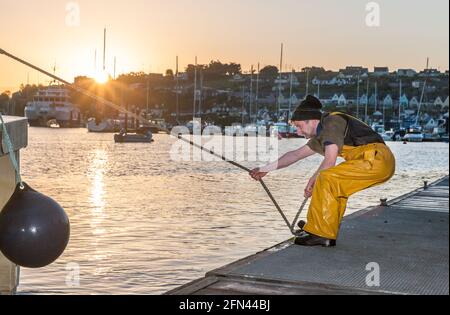 Crosshaven, Cork, Irland. Mai 2021. Der Fischer Billy Moriarty vom Trawler Celtic Sun bindet sein Boot bei Sonnenaufgang an den Pier in Crosshaven, Co. Cork, Irland. - Credit; David Creedon / Alamy Live News Stockfoto