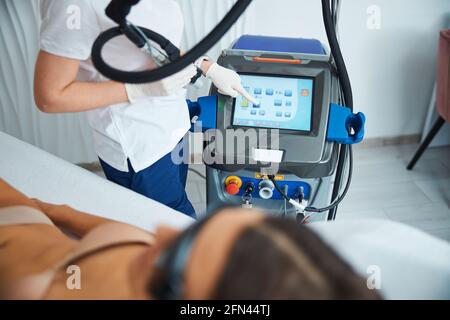 Kosmetikerin, die den Patienten für einen Haarentfernung vorbereitet Stockfoto
