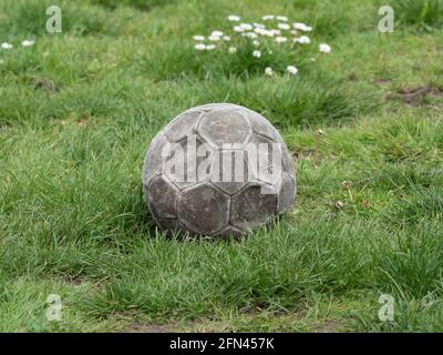 Alt verwittertes Leder Fußball ist flach und liegt in der Gras Stockfoto