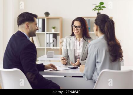 Frau Finanzberaterin, die das Familienpaar über den Kauf berät Haus Stockfoto