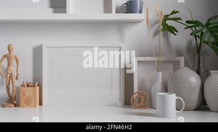 Nahaufnahme des weißen Concept-Arbeitstisches mit Zubehör, Rahmen, Dekorationen und Kopierraum Stockfoto