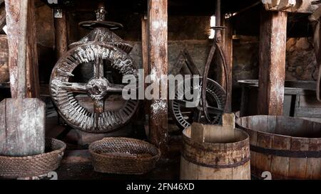 Eine alte Handmühle aus Steinen und Holz. Mehlschleifvorrichtung. Authentisches Kunsthandwerk Stockfoto