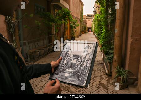 (210514) -- KASHGAR, 14. Mai 2021 (Xinhua) -- Mamattursunjian Mamatimen malt in einer Gasse in der alten Stadt Kashgar in der Autonomen Region Xinjiang Uygur im Nordwesten Chinas, 6. Mai 2021. Die dominante Farbe der Wohnungen in der antiken Stadt Kashgar in Xinjiang ist tiefgelb. Aber in den Werken des 26-jährigen lokalen Malers Mamattursunjian Mamatimen werden mehr Farben wie Orange, Weiß, Lila, Blau verwendet, um die Stadt zu malen. Das ist sein Lebensgefühl und auch ein Gefühl, das die Jugendlichen in Kashgar teilen, sagte Mamattursunjian. „Es braucht Mut, die Tradition zu durchbrechen.“ Mamattursunjian Stockfoto