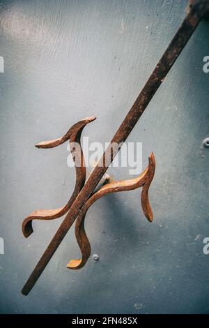 Detail eines alten schmiedeeisernen Türknopfes an einer Tür Stockfoto