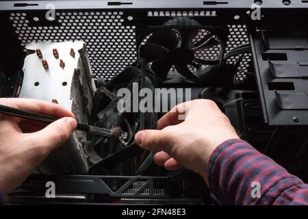 Der Computertechniker reinigt den CPU-Kühler und die Hardware Stockfoto