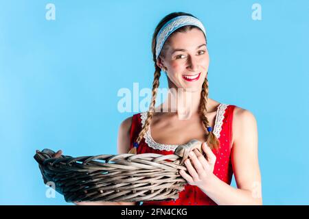 Frau in Dirndl oder Bayerische Tracht tragen Weidenkorb Stockfoto