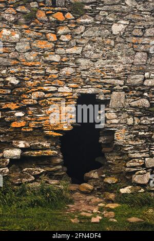 Dunkles Loch in einer alten Steinmauer. Eintritt in die Ruinen einer alten Burg. Mystery und Dunkelheit. Stockfoto