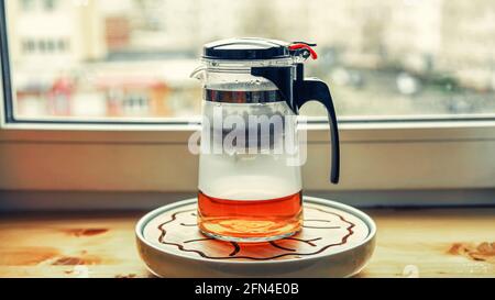 Teekannen aus Kunststoff-Glas mit Knopf und Kolben zum Brühen von Tee Brühen Stockfoto