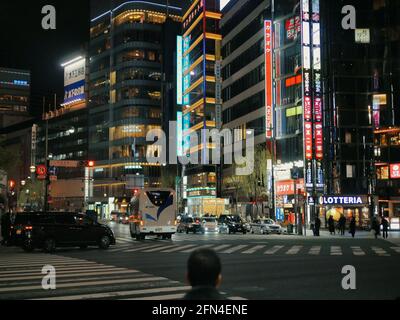 Nachtstraßen des Distrikts Kabukicho, Shinjuku. Kopf eines Japaners in der Mitte, der die neonbeleuchteten Wolkenkratzer anschaut. Modernes Leben und Industrie. Stockfoto