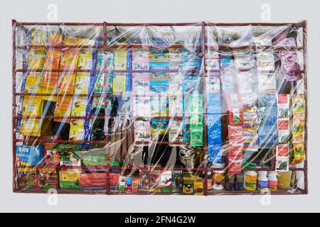 Gegrilltes Fenster eines Nachbarschafts-Sari-Ladens, geschützt durch Plastikabdeckung als Covid-Vorsichtsmaßnahme, Verkauf von Tierarzneimitteln, Philippinen Stockfoto