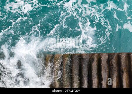 Steintreppen gehen im stürmischen Meerwasser hinunter, Blick von oben. Porto Santo Island, Portugal Stockfoto