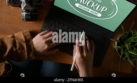 Aufnahme von Frauen, die auf einer Tablet-Tastatur tippen Halten Sie den Stylus Pen auf dem Holztisch Stockfoto