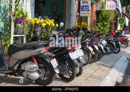 Vietnamesische Motorräder und Motorroller blockieren die Fußgängerpassage, so dass die Öffentlichkeit auf der Straße laufen muss, Da Nang, Vietnam Stockfoto