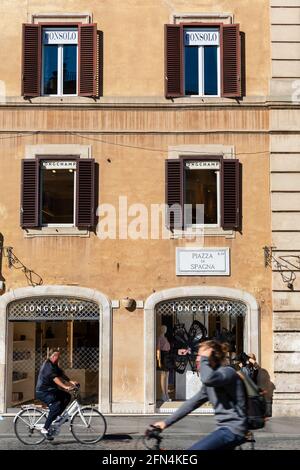 Radfahrer kommen an luxuriösen Modegeschäften auf der Piazza di Spagna, Rom, Italien vorbei. Stockfoto