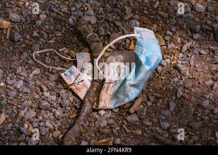 Eine medizinische Maske wird auf einer Wiese weggeworfen und Verschmutzt die Umwelt Stockfoto