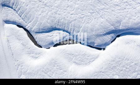 Luftaufnahme des verschneiten Pla de Beret im Winter. Mäander des Flusses Noguera Pallaresa in der Nähe seiner Quelle (Aran-Tal, Katalonien, Spanien, Pyrenäen) Stockfoto