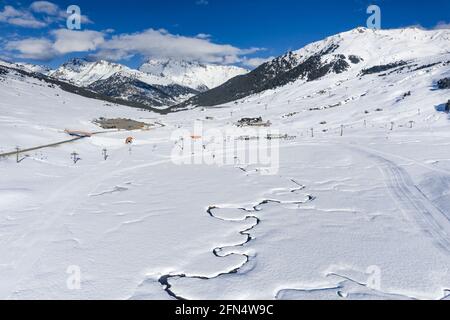 Luftaufnahme des verschneiten Pla de Beret im Winter. Mäander des Flusses Noguera Pallaresa in der Nähe seiner Quelle (Aran-Tal, Katalonien, Spanien, Pyrenäen) Stockfoto