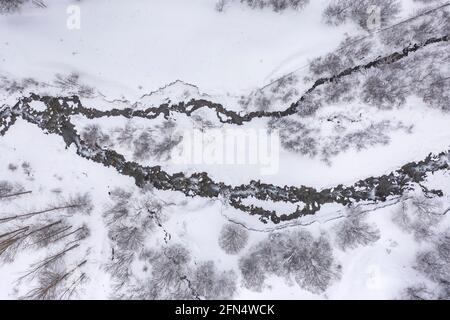 Luftaufnahme des Flusses Unhòla bei winterlichen Schneefällen. (Aran Valley, Catalonia, Spain, Pyrenees) ESP: Vista aérea del Río Unhòla en plena nevada Stockfoto