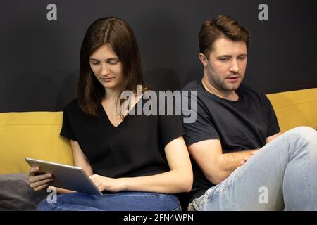 Fokussierte Frau liest Geliebte Nachricht wandte sich zurück zu besorgten Freund Stockfoto