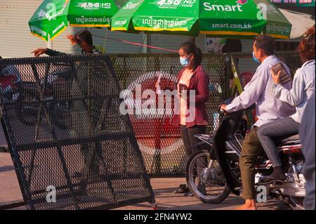 Phnom Penh, Kambodscha. 14. Mai 2021. Nach 4 Wochen totaler Sperre teilt die Regierung Phnom Penh aufgrund des anhaltenden COVID-Anstiegs 19 weiterhin in 3 Farbzonen (rot, orange & gelb) auf. Eine junge kambodschanische Frau zeigt ihre Unterlagen (Nachweis des Wohnsitzes) An einem Polizeikontrollpunkt in einer „Roten Zone“, was ein hohes Infektionsrisiko bedeutet. Quelle: Kraig lieb / Alamy Live News Stockfoto