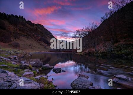 Sonnenaufgang im See Barratge de Varradòs, im Herbst (Aran-Tal, Katalonien, Spanien, Pyrenäen) ESP: Amanecer desde el lago Barratge de Varradòs, en otoño Stockfoto