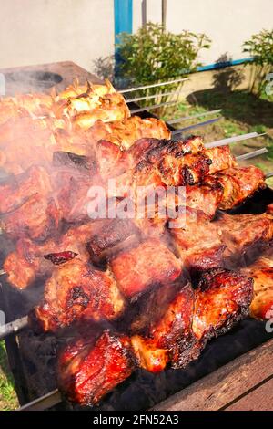 Marinierter Schaschlik, der auf einem Barbecue-Grill über Holzkohle zubereitet wird. Schaschlik oder Schischkebab in Europa beliebt. Stockfoto