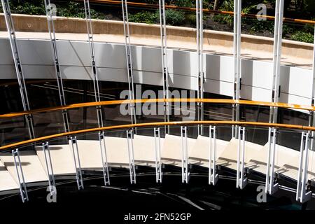 Abstraktes Bild einer Außentreppe aus Beton, Glas, Stahl und Holz für die Handläufe. Licht und Schatten betonen seine Form. Stockfoto